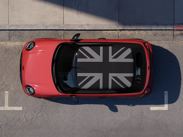 Top view of the MINI Cooper Convertible in Chili Red and MINI Yours Roof standing on a street.